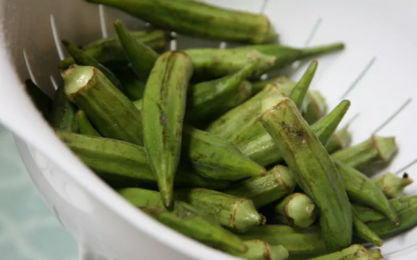 4K Ultra HD PC desktop wallpaper: close-up of fresh green okra in a white colander, showcasing vivid texture and color.