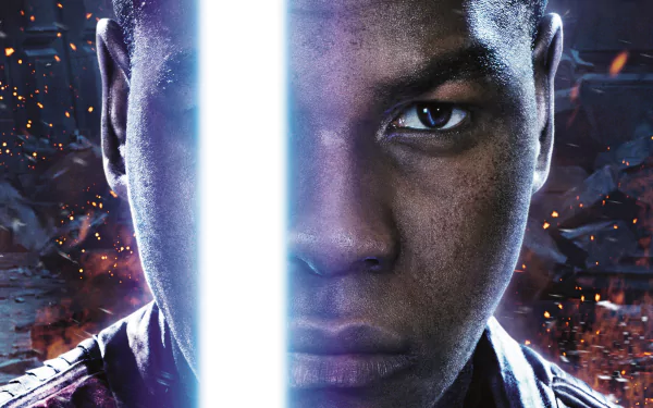 HD desktop wallpaper featuring John Boyega as Finn from Star Wars Episode VII: The Force Awakens, with a glowing lightsaber between his intense gaze.