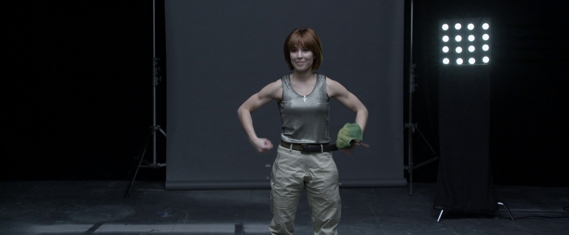 HD desktop wallpaper featuring celebrity Noomi Rapace standing confidently with a serious expression against a dark studio background.