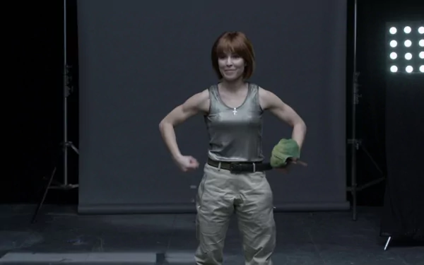 HD desktop wallpaper featuring celebrity Noomi Rapace standing confidently with a serious expression against a dark studio background.