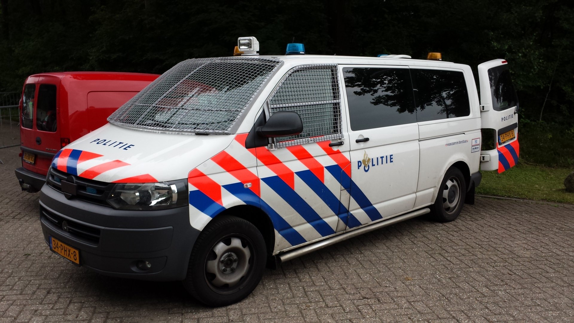 4K Ultra HD desktop wallpaper featuring a white police van with red and blue stripes parked on a paved area surrounded by greenery.