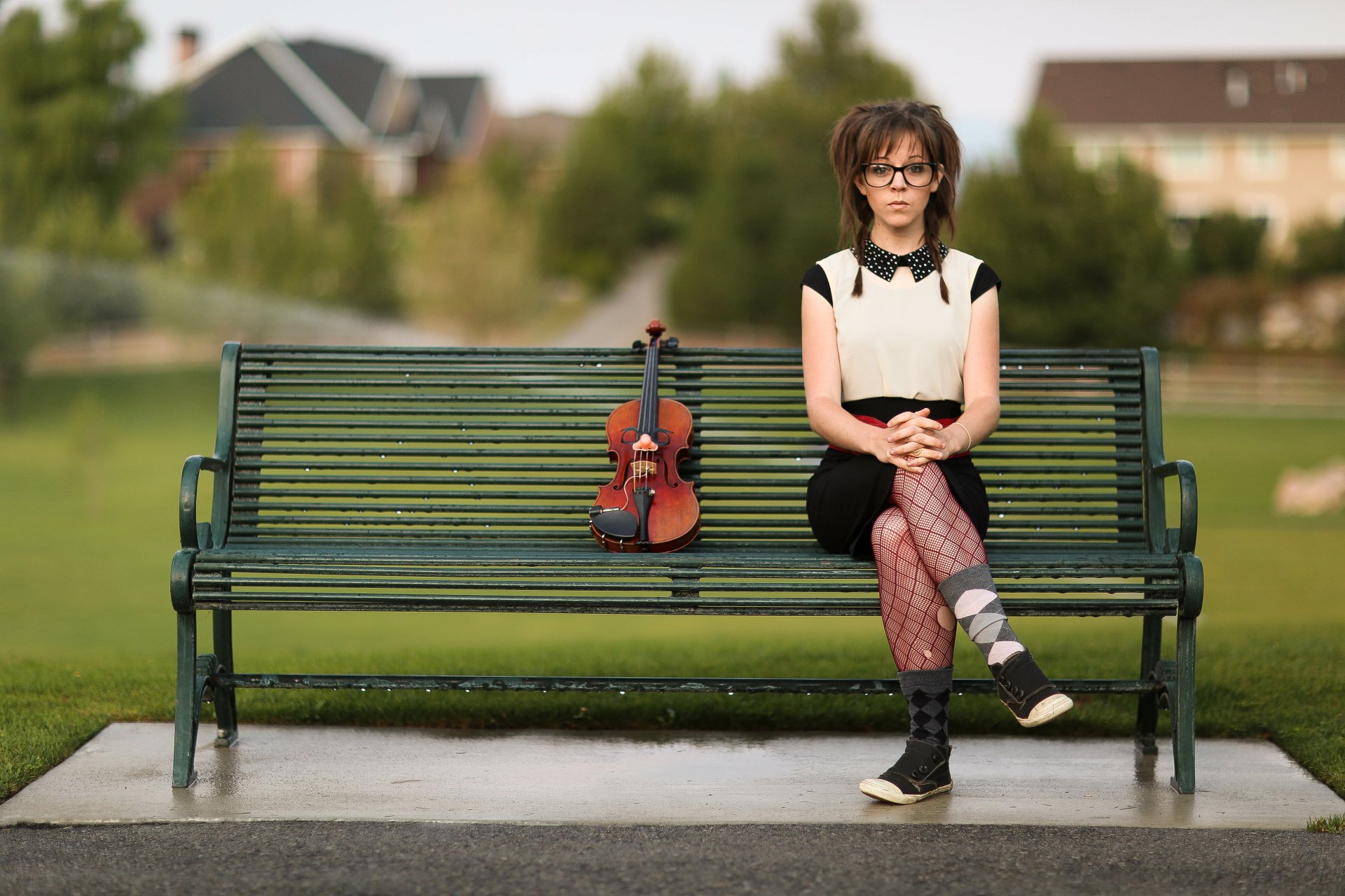 Lindsey Stirling sits on a park bench with a violin beside her, captured in a 4K Ultra HD music-themed PC desktop wallpaper.