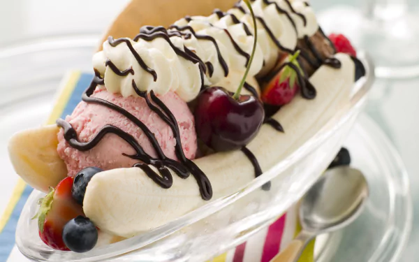 A vibrant banana split adorned with scoops of ice cream, whipped cream, chocolate drizzle, and fresh cherries, set against a bright, colorful background. 4K Ultra HD desktop wallpaper.