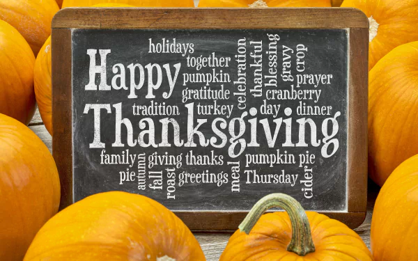 4K Ultra HD Thanksgiving holiday desktop wallpaper featuring a chalkboard with festive words surrounded by bright orange pumpkins.