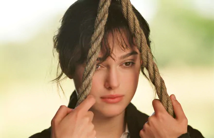 A close-up of Keira Knightley in a contemplative moment, holding onto ropes, from the movie Pride & Prejudice. This 4K Ultra HD wallpaper captures a poignant expression.