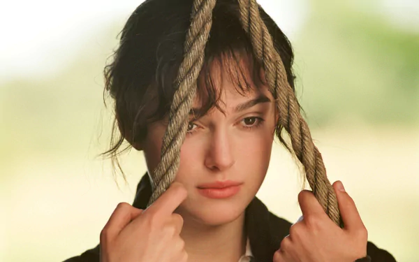 A close-up of Keira Knightley in a contemplative moment, holding onto ropes, from the movie Pride & Prejudice. This 4K Ultra HD wallpaper captures a poignant expression.