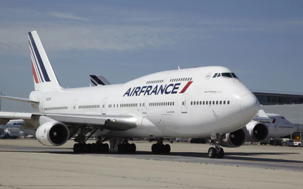 A Boeing 747 passenger plane, branded with Air France livery, is seen on the tarmac, showcasing its impressive design and stature in this high-definition desktop wallpaper.