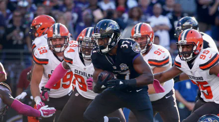 HD PC desktop wallpaper featuring a Baltimore Ravens player running with the ball against Cleveland Browns defenders during a football game.