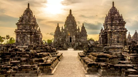 A stunning view of Prambanan Temple in Java, Indonesia, showcasing intricate Hindu architecture against a dramatic sunset, perfect for a desktop wallpaper.