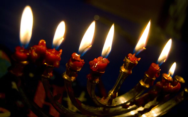 4K Ultra HD PC desktop wallpaper showing a close-up Hanukkah menorah with glowing lit candles and warm, festive holiday lighting