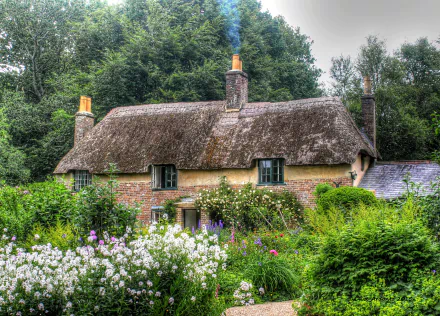 A charming cottage with a thatched roof surrounded by a vibrant garden filled with flowers. Lush greenery and trees create a peaceful, idyllic atmosphere.