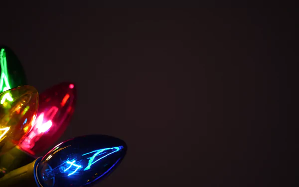 Close-up of colorful Christmas lights glowing against a dark background, captured in stunning 4K Ultra HD for a festive holiday PC desktop wallpaper.