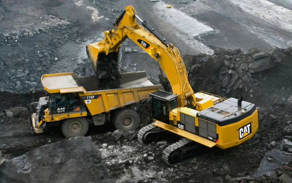 HD desktop wallpaper featuring a yellow Caterpillar vehicle operating in a construction site, with an excavator loading dirt into a dump truck.