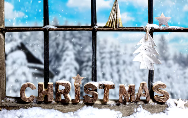 A snowy window scene adorned with Christmas ornaments and snow-covered letters spelling CHRISTMAS, creating a festive holiday atmosphere. 4K Ultra HD wallpaper.