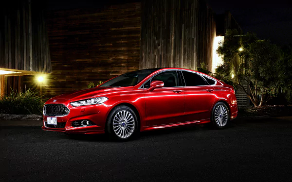 HD desktop wallpaper featuring a red Ford Mondeo car parked at night in front of a wooden building with surrounding trees and ambient lighting.