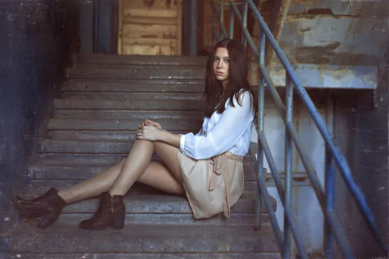 HD PC desktop wallpaper background showing a long-haired woman model sitting on worn concrete stairs in a light blouse and skirt, leaning against a metal railing.