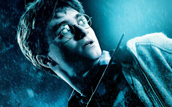 A dramatic HD wallpaper featuring Daniel Radcliffe as Harry Potter in Harry Potter and the Half-Blood Prince, capturing a tense moment in the rain.