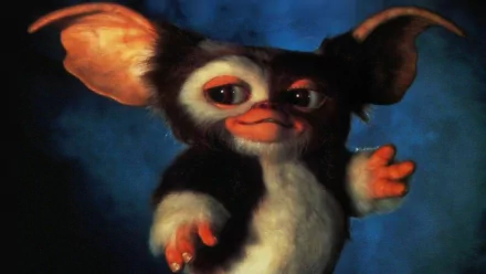 Gizmo (Gremlins) from Gremlins 2: The New Batch — HD PC desktop wallpaper/background: close-up of the Mogwai reaching out against a blue backdrop.