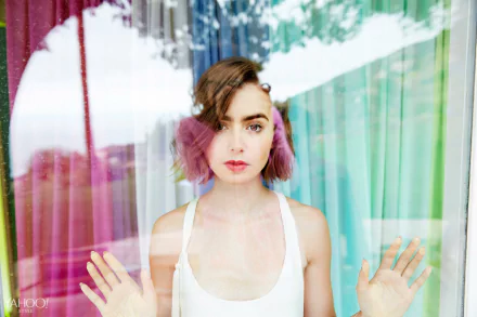 Brunette actress Lily Collins with short hair looks through a glass window, captured in a vibrant 4K Ultra HD PC desktop wallpaper and background.
