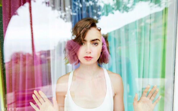 Brunette actress Lily Collins with short hair looks through a glass window, captured in a vibrant 4K Ultra HD PC desktop wallpaper and background.