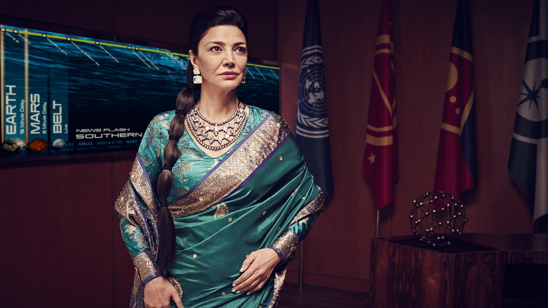 HD PC desktop wallpaper — TV show The Expanse: a dignified woman in an ornate teal sari and jewelry stands in a command room with holo displays and faction banners.