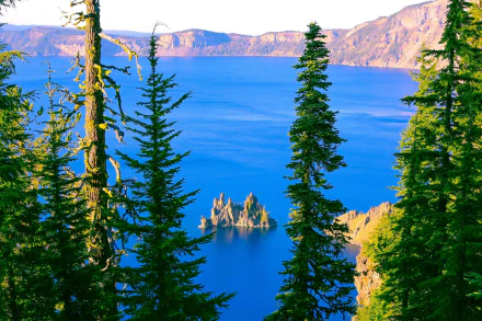 Crater Lake framed by evergreen trees, vivid blue water and volcanic island spires — 2K Quad HD PC desktop wallpaper and background.