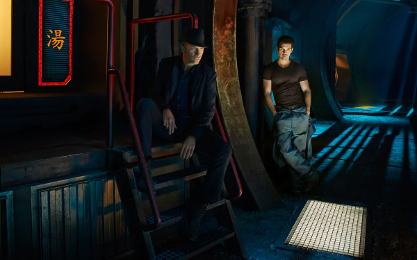 HD desktop wallpaper from TV series The Expanse: James Holden stands in a blue-lit ship corridor while a crewmate sits on metal steps amid dramatic shadows.