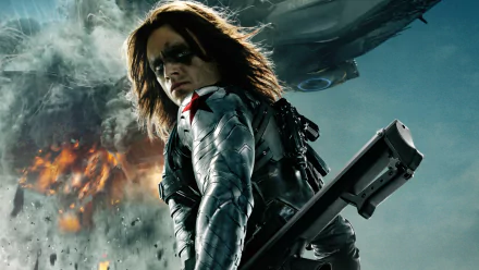 A dramatic HD wallpaper from Captain America: The Winter Soldier, featuring a determined soldier with long hair and a unique arm, set against a backdrop of explosive action.