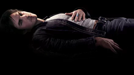 A dramatic HD wallpaper from The Vampire Diaries, featuring a character lying down against a dark backdrop, exuding a mysterious and moody atmosphere.
