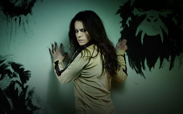 HD PC desktop wallpaper featuring a dark, intense scene from the TV show 12 Monkeys, with a woman pressing against a wall covered in ominous black handprints.