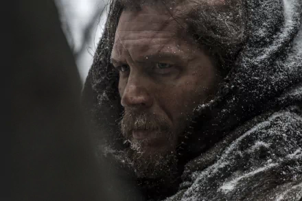 A close-up of Tom Hardy in a snowy, rugged setting from the movie *The Revenant*, capturing his intense expression amidst a harsh wilderness backdrop. HD wallpaper for fans of the film.