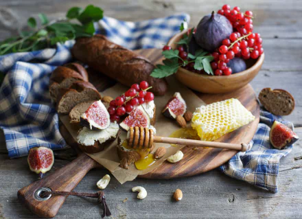 HD PC desktop wallpaper still life: figs, red currants, sliced bread, honeycomb with dipper on a wooden board, nuts and blue check cloth.