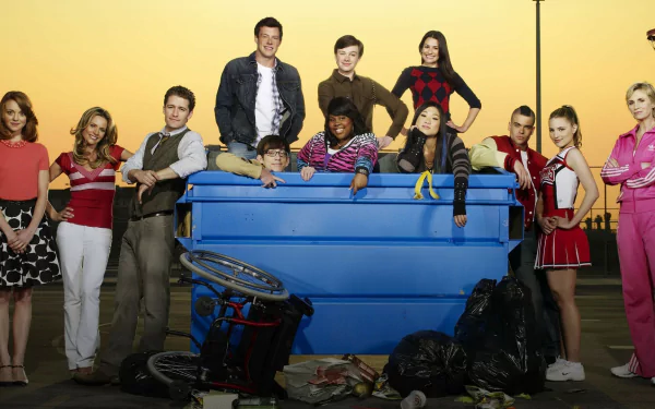 HD PC desktop wallpaper for TV show Glee: a diverse group posed around a blue dumpster against a bright yellow backdrop.