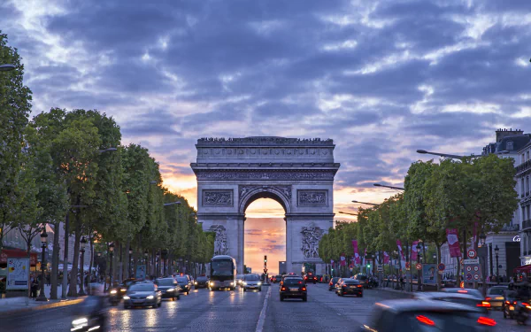 A stunning view of the Arc de Triomphe in Paris, framed by tree-lined streets and a colorful sunset, captured in high-definition for a vibrant desktop wallpaper.