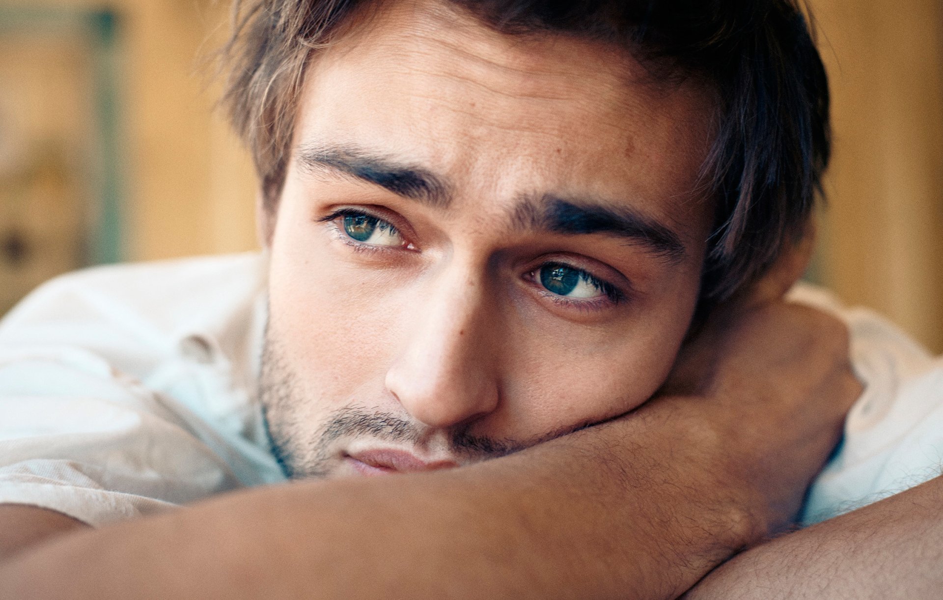 HD desktop wallpaper of English actor Douglas Booth resting his head on his arm, showcasing a close-up of his contemplative expression.