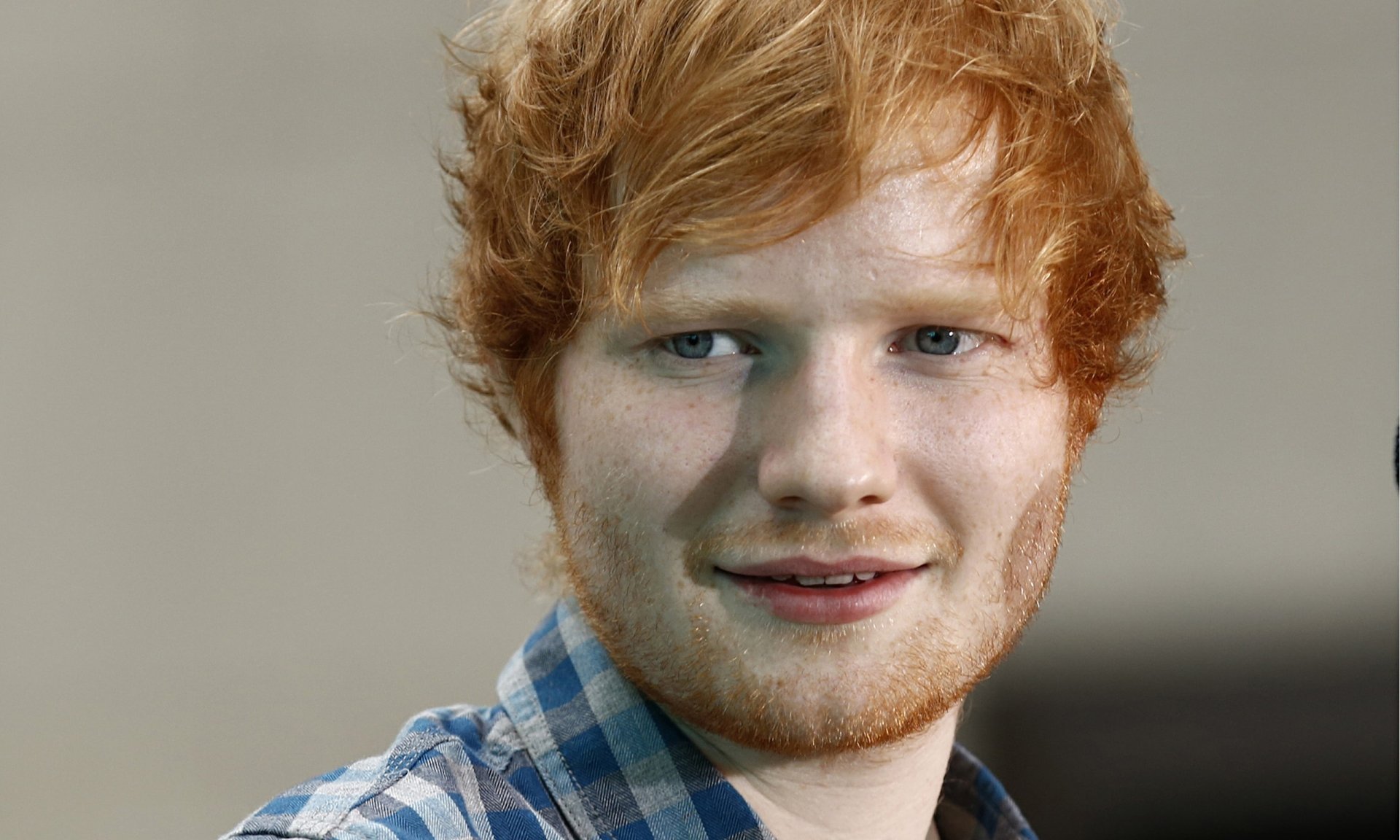 HD desktop wallpaper of English singer Ed Sheeran, featuring a close-up portrait with a neutral background.