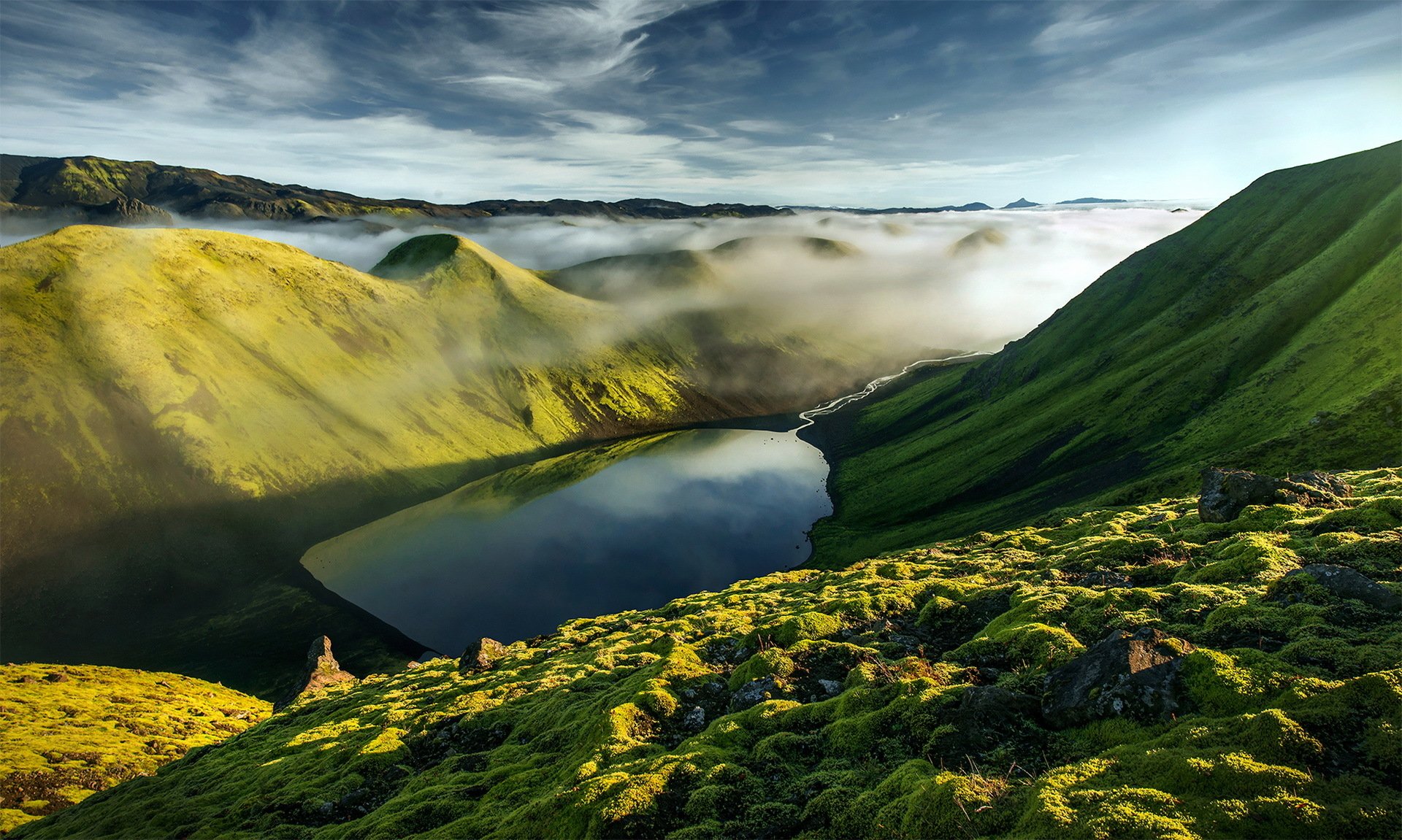 HD desktop wallpaper showcasing a serene mountain valley with a lake, blanketed in fog under a dramatic sky, highlighting nature’s tranquil landscape.