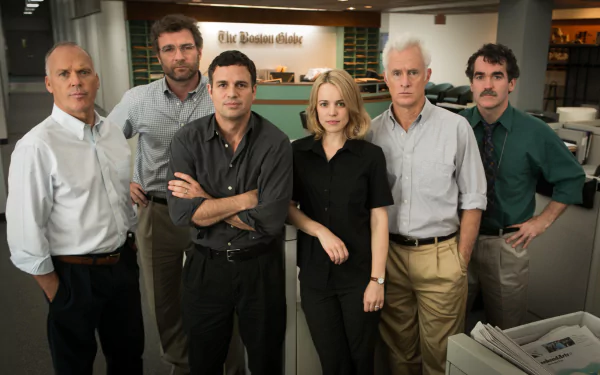 HD desktop wallpaper of the Spotlight (2015) cast including Mark Ruffalo, Michael Keaton, Rachel McAdams, and others in a newsroom setting at The Boston Globe.