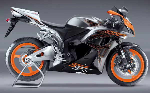 HD PC desktop wallpaper showing a side-profile metallic silver and orange Honda CBR600RR sport motorcycle (vehicle) on a neutral gray background.