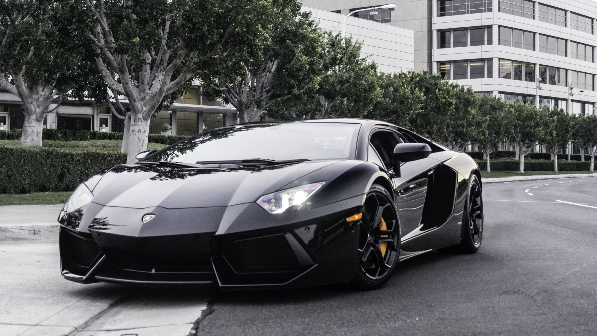 A sleek black Lamborghini Aventador parked on a city street, showcased in a sharp 4K Ultra HD PC desktop wallpaper background.