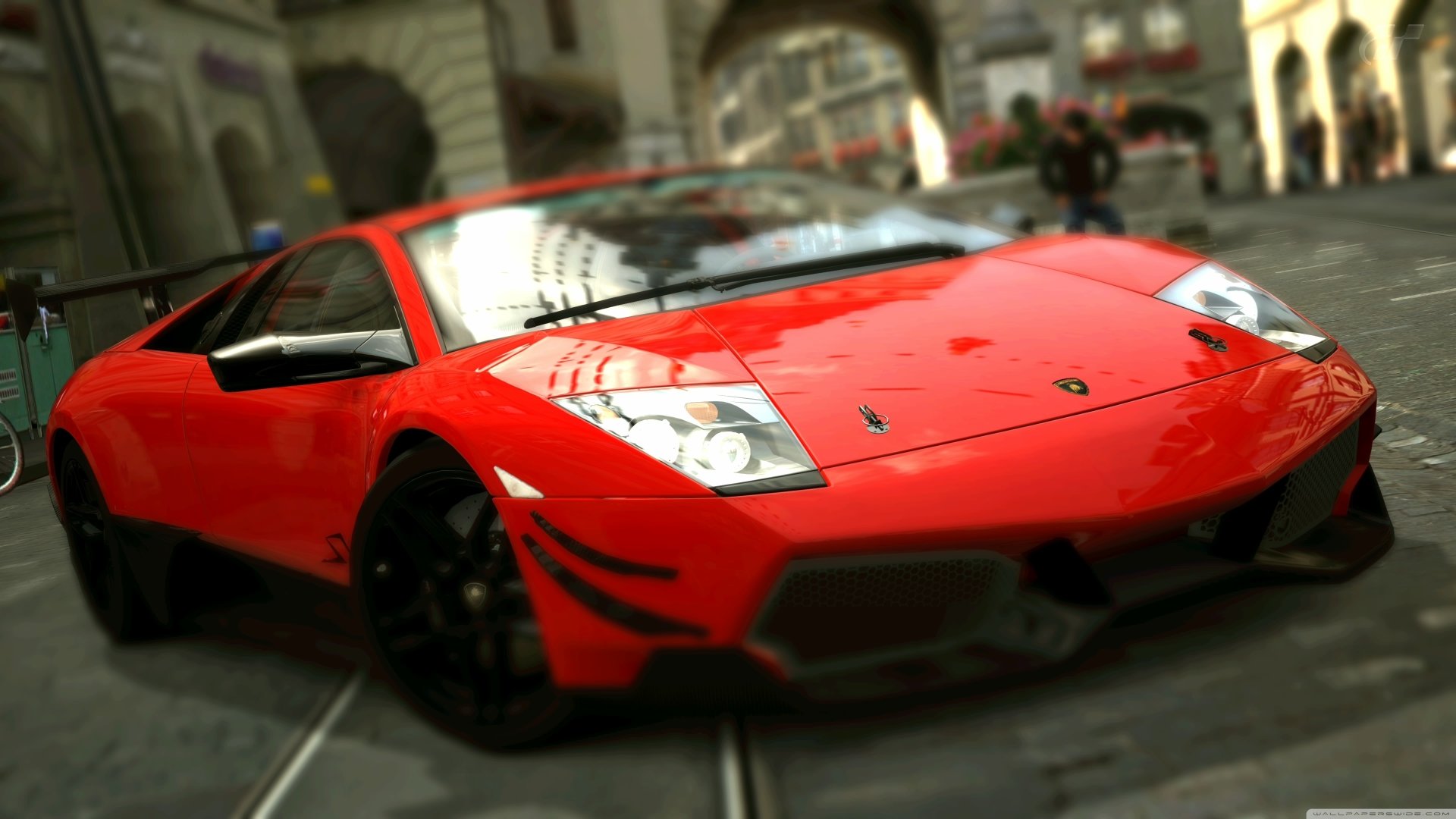 Low-angle 4K Ultra HD desktop wallpaper of a red Lamborghini Murcielago LP parked on a cobblestone street, highlighting its glossy finish and aggressive stance.