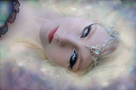 A dreamy fantasy scene featuring a blonde woman with blue eyes and a delicate bindi, exuding a mystical mood. A captivating HD wallpaper that enhances any desktop background.