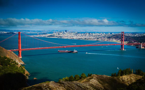 Vibrant HD image of the Golden Gate Bridge spanning San Francisco Bay, California, with a clear horizon and city skyline in the background.