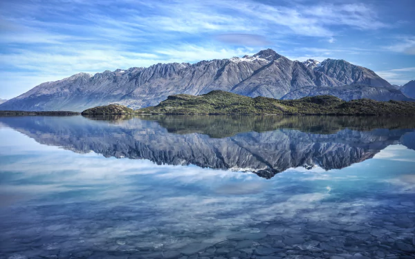 A stunning 4K Ultra HD image showcasing serene natural scenery, featuring majestic mountains reflected in a calm lake under a clear blue sky.