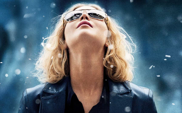 HD PC desktop wallpaper: blonde woman in sunglasses and leather jacket gazes upward amid falling snow — promotional-style portrait referencing the film Joy (2015).