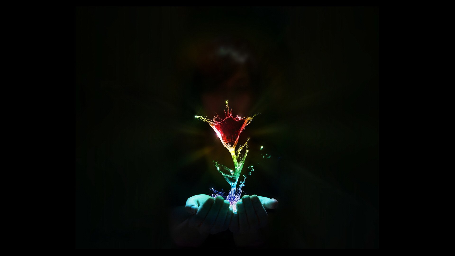 Artistic HD desktop wallpaper featuring a hand releasing colorful, dynamic light shapes against a dark background.