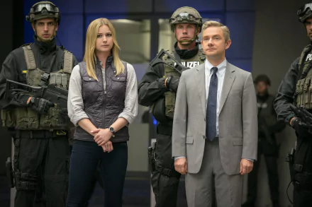 Emily Vancamp and Martin Freeman stand together in a tense scene from Captain America: Civil War, surrounded by armed officers, capturing a pivotal moment in the movie.