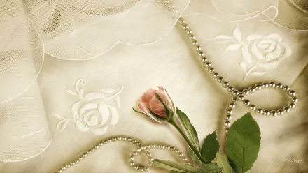 HD PC desktop wallpaper featuring a vintage-style close-up of a delicate pink rose with green leaves, draped over embroidered fabric and a string of pearls.