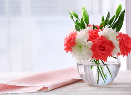 A 4K Ultra HD still life photograph of red roses, white eustoma flowers, and green leaves arranged in a clear vase beside a folded handkerchief on a bright surface.