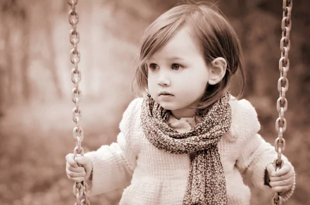 Sepia-toned 4K Ultra HD desktop wallpaper capturing a cute little girl on a swing, showcasing charming child photography in soft, nostalgic tones.